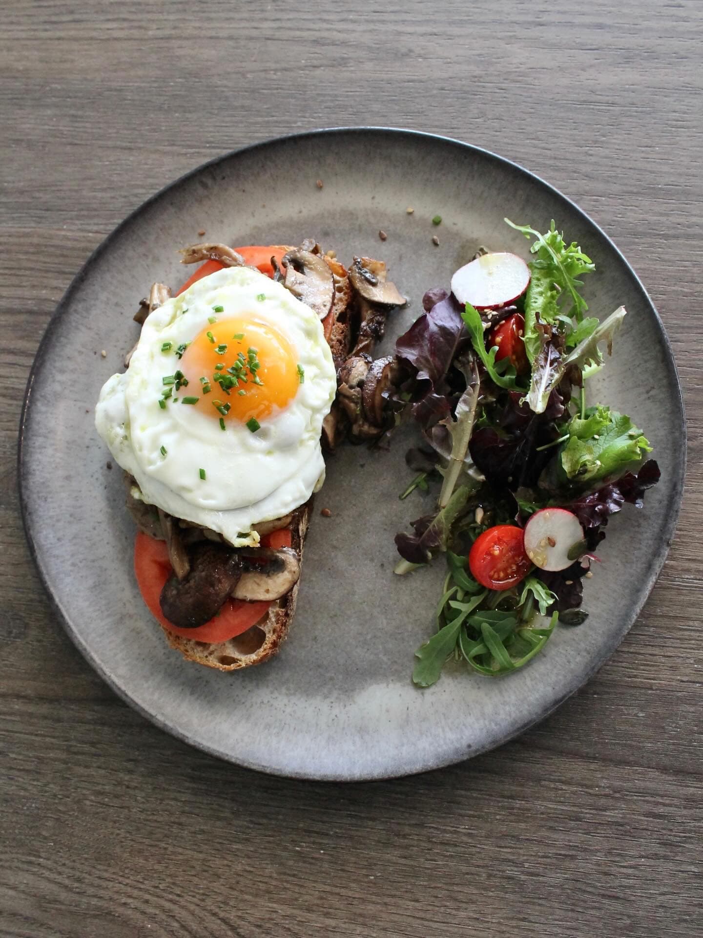 Sautéed mushrooms and a fried egg on sourdough with salad